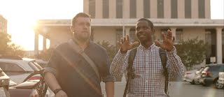 Founders, Bernard Worthy and Justin Straight, stand side by side in a parking lot looking up.