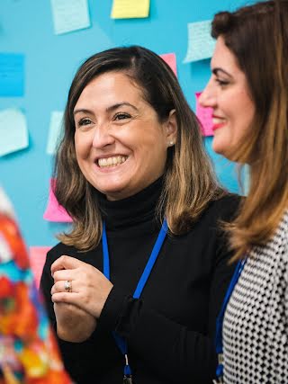 2 women laughing, 1 in focus.