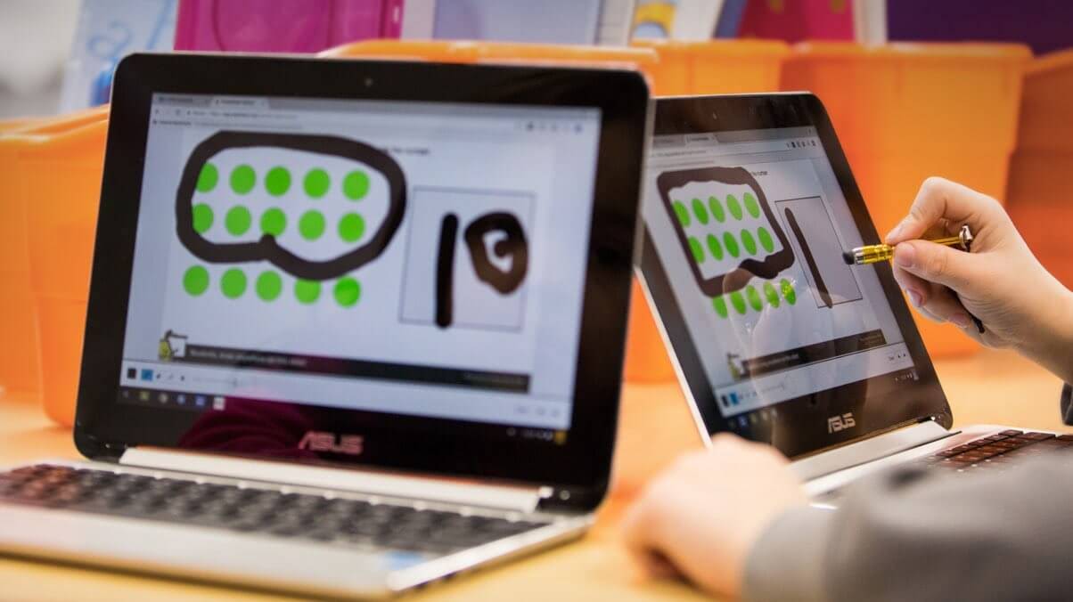 Et barn skriver med penn på en Chromebook med berøringsskjerm