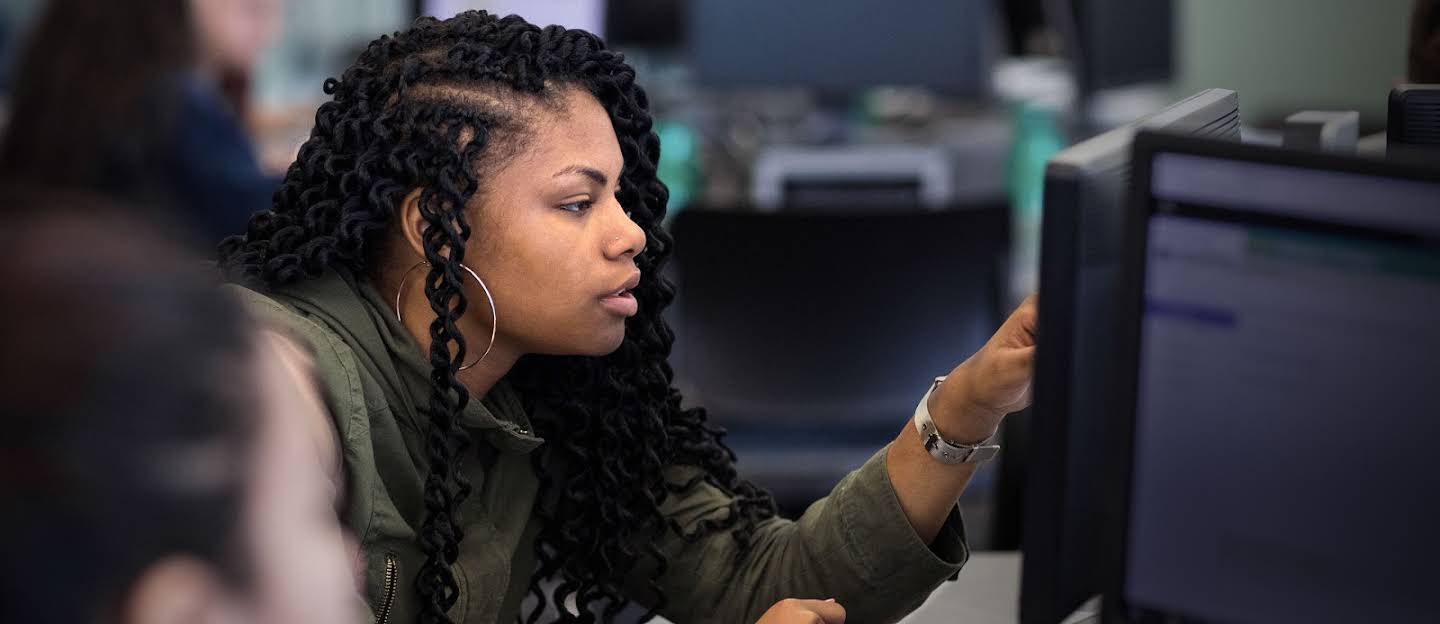 Hero video. Girl, teen or higher education aged, is looking at something on a computer screen.